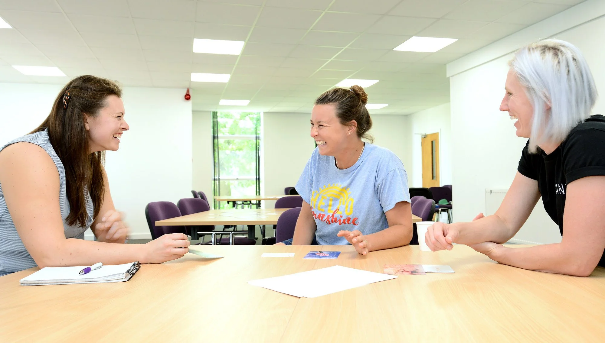 Three women at a table in a learning and development session..