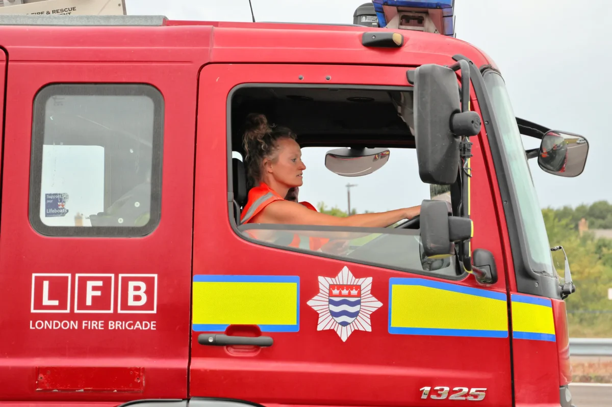 Female fire fighter driving a fire engine
